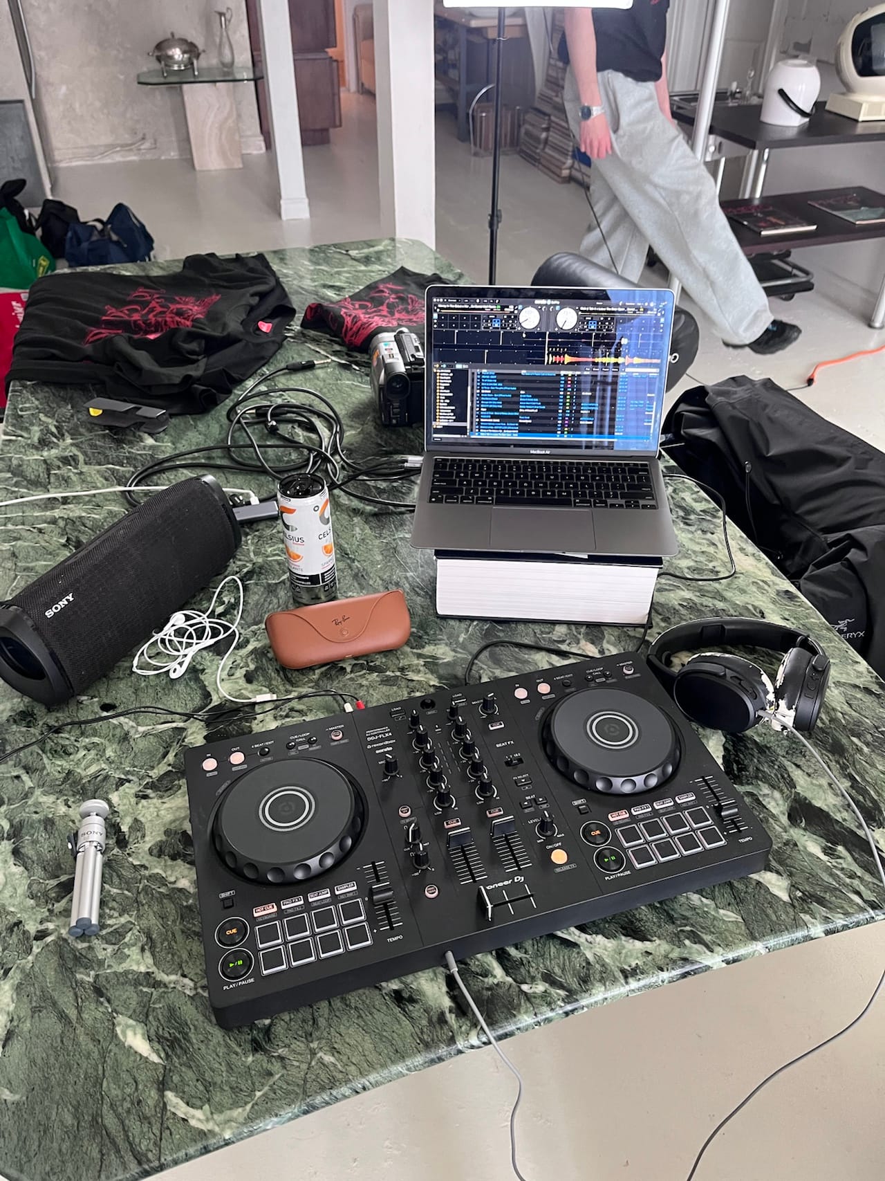 Une console de DJ, un ordinateur et des haut-parleurs sur une table en marbre vert